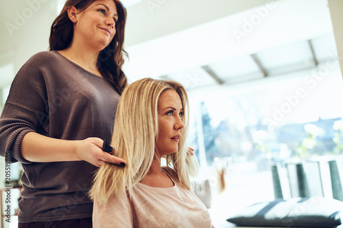 Young woman talking with her hairstylist in a salon