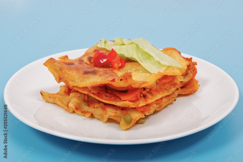 Lasagna with vegetables on a blue Lasagna with vegetables on a blue