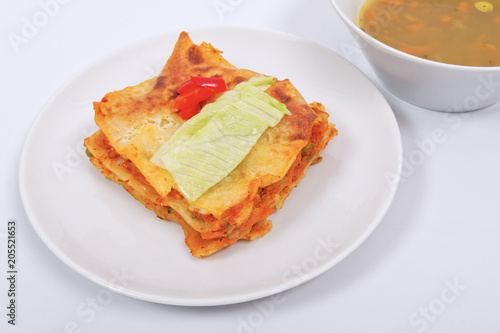 Lasagna with vegetables on a white