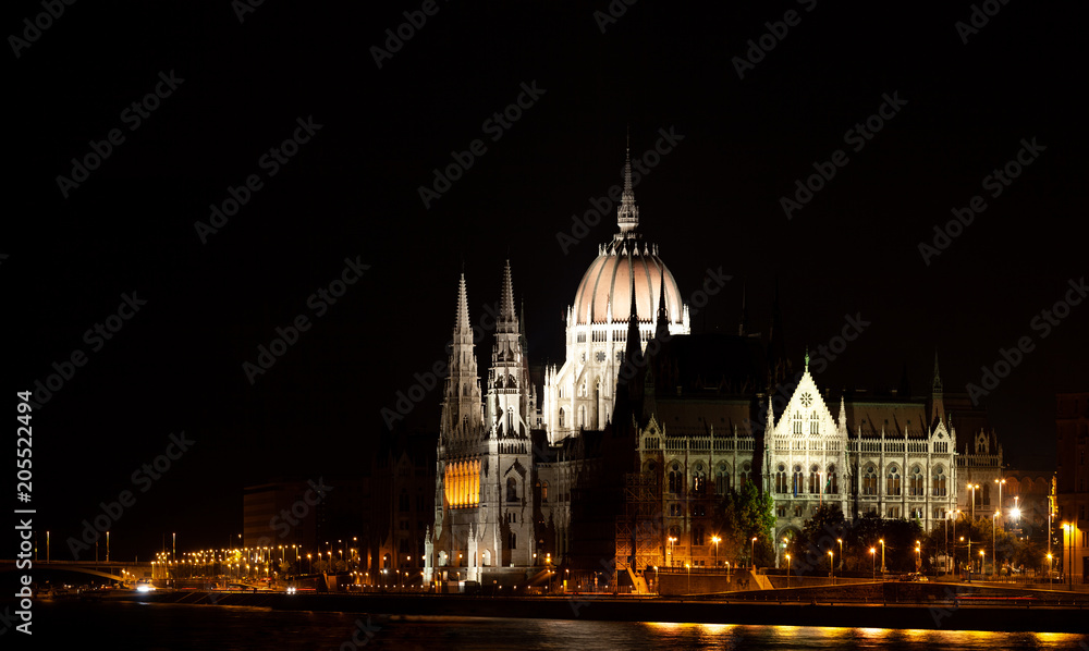 Illuminated Budapest parliament building at night with black sky and reflection in Danube river