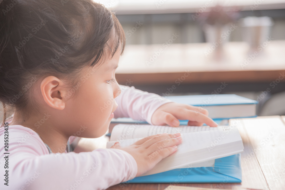 cute smiling kid reading book in children room