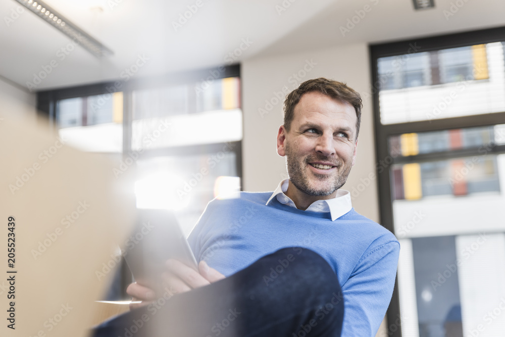 Smiling businessman using tablet in office Smiling businessman using tablet in office