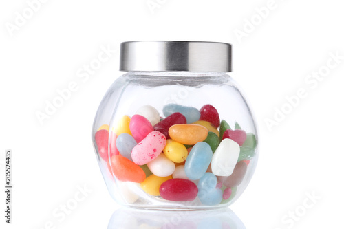 a glass jar half  full of colored candies with isolated on white background with clipping path