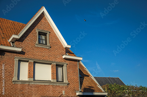 Detail of brick building facade and roofs at sunset in the City Center of Tielt. Charming and quiet village in the countryside, near Ghent and surrounded by agricultural fields. Western Belgium.