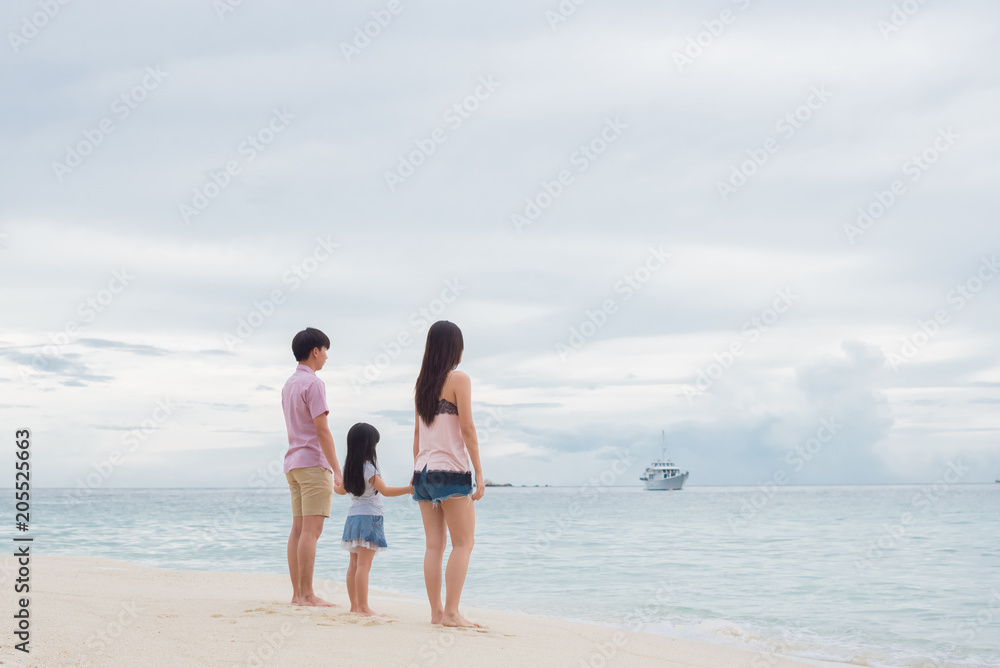 Happy young family having fun running on beach . Family traveling concept