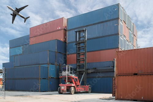 Forklift lifting container box loading to container depot with cargo airplane use for cargo import, export, logistics background.