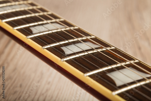 Old beautiful electric guitar on a background of wood.
