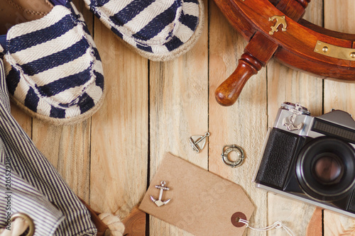 Striped slippers, camera, bag and maritime decorations, top view