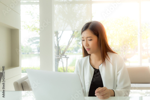 Attractive beautiful business woman work on notebook computer. Charming beautiful woman looks busy and stressed. Gorgeous girl think about her project. Glamour lady gets hardworking. She get trouble