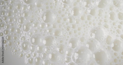 A very close video of milk bubbles popping. photo