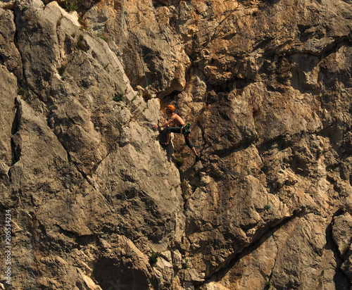 Rock climber resting during hard climb. photo