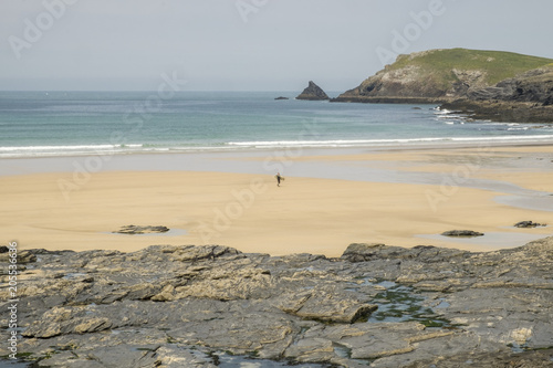 Lone surfer on beach Treyarnon Bay Cornwall photo