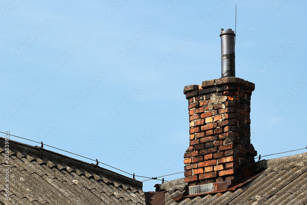 Old brick smoke stack on a slate roof