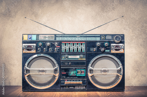 Retro design ghetto blaster stereo radio cassette tape recorders boombox from circa 80s front concrete wall background. Vintage instagram old style filtered photo