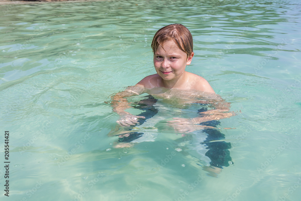 boy enjoys swimming in the tropical ocean