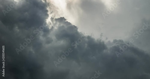 Time lapse clip of gray fluffy curly rolling clouds before storm
