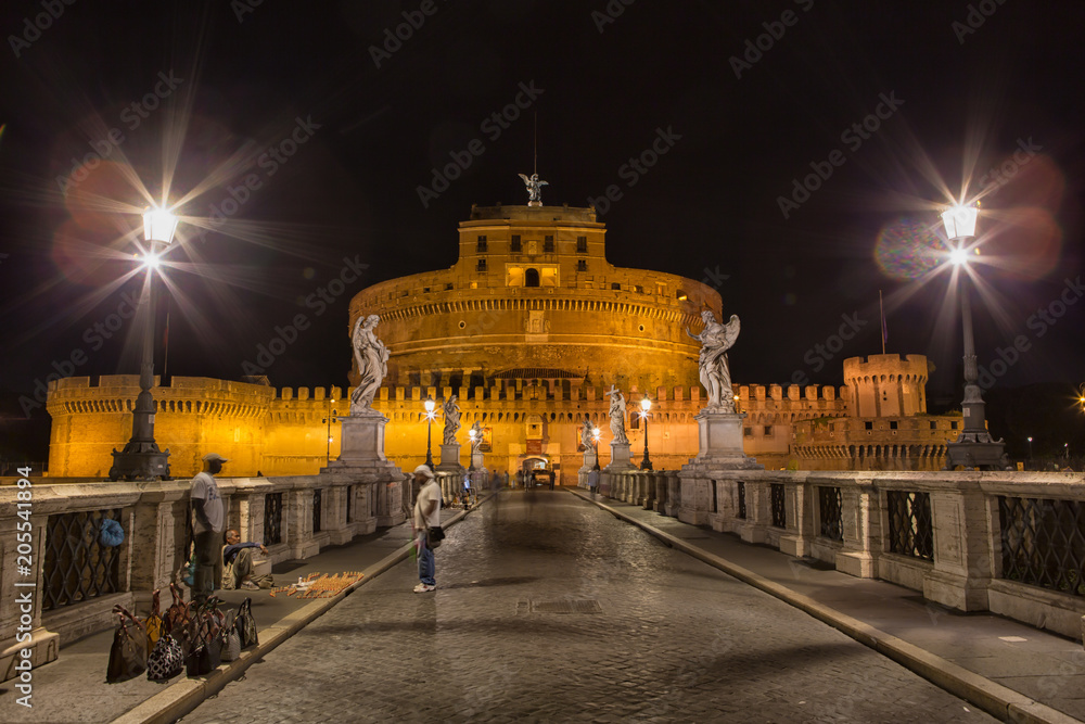 Castel Sant'Angelo (Hadrian's Tomb) in Rome, Lazio, Italy seen from the Ponte Sant'Angelo illuminated at night. 