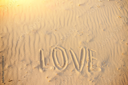 big text LOVE in the sand of the beach