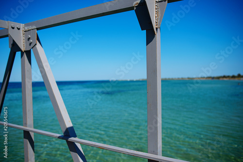 Swimming ladder from stainless steel for descent into sea water on pier. Silent bay ideal for children swim and play