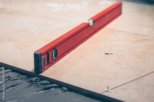 Wallpaper Mural The working tiler monitors the quality of work, the professional checks the building level Torontodigital.ca