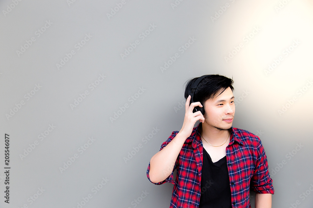 Portrait charming handsome young asia guy: Attractive handsome man is feeling relaxed and enjoying life. Cool guy get smile and happy when asia man listen nice music. copy space, sunlight background Portrait charming handsome young asia guy: Attractive handsome man is feeling relaxed and enjoying life. Cool guy get smile and happy when asia man listen nice music. copy space, sunlight background