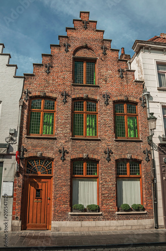 Brick facade of house in typical style of the Flanders’s region in street of Bruges. With many canals and old buildings, this graceful town is a World Heritage Site of Unesco. Northwestern Belgium.