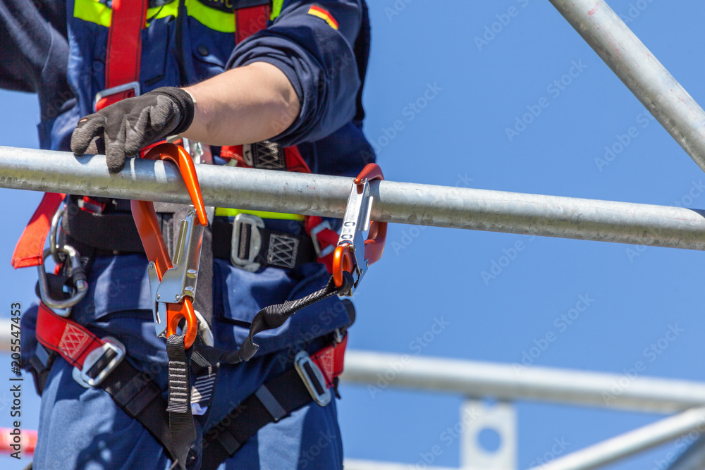 Man from german technical emergency service secured by a carabiner hook Man from german technical emergency service secured by a carabiner hook