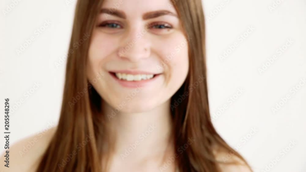 beautiful happy girl posing positively against a white wall and blowing kisses. closeup handheld shoot, shallow depth of field beautiful happy girl posing positively against a white wall and blowing kisses. closeup handheld shoot, shallow depth of field