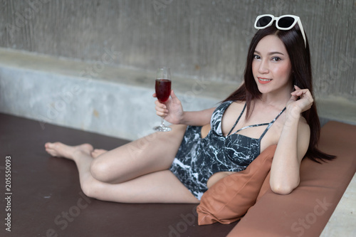 wwoman on deckchair and holding a glass in pool
