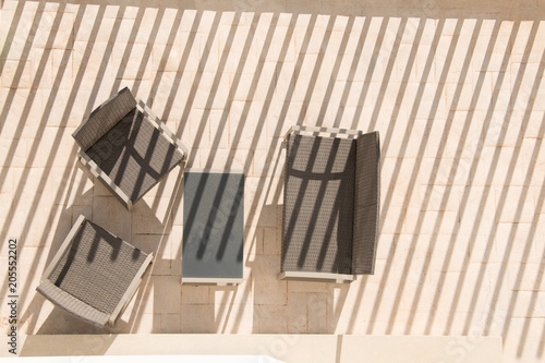 Modern garden furniture. Table, chairs view from above. Minimalism. Sharp shadows.