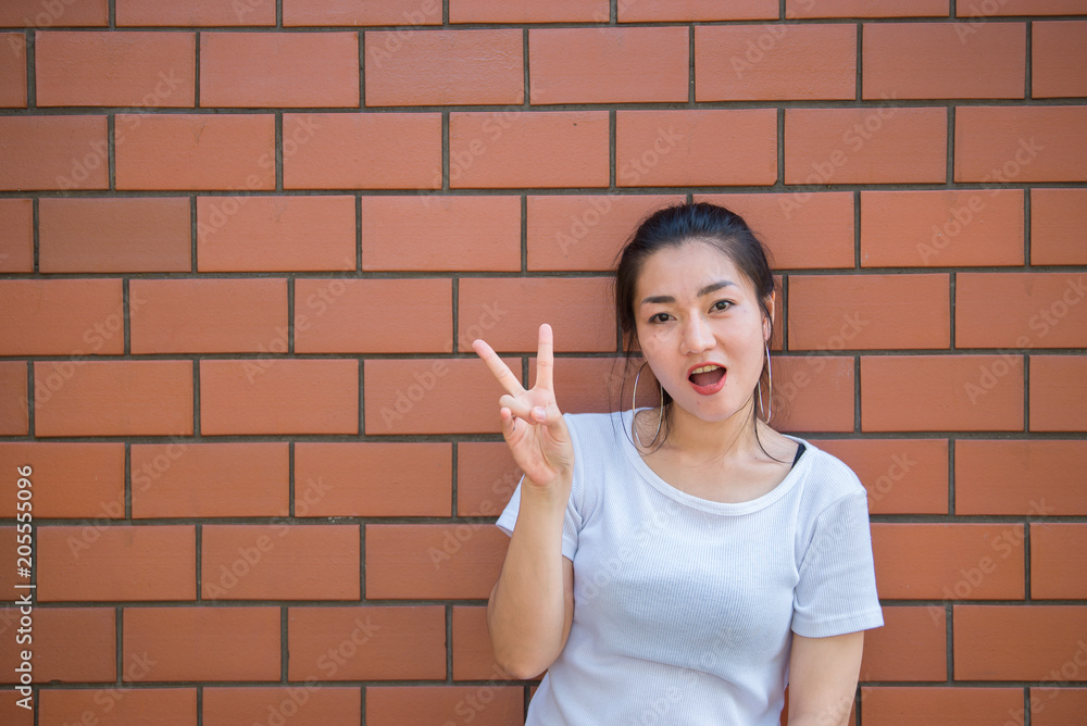 Portrait of beautiful asian chic girl pose for take a picture on brick wall,Lifestyle of teen thailand people,Modern woman happy concept Portrait of beautiful asian chic girl pose for take a picture on brick wall,Lifestyle of teen thailand people,Modern woman happy concept