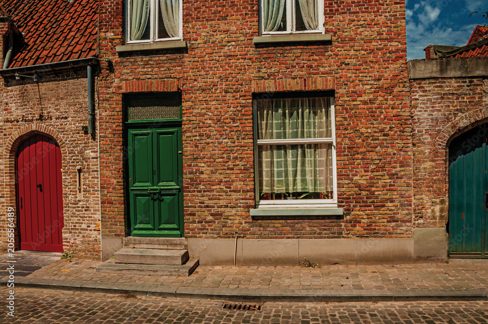 Brick facade of houses in Flanders typical style at street of Bruges. With many canals and old buildings, this graceful town is a World Heritage Site of Unesco. Northwestern Belgium. Retouched photo