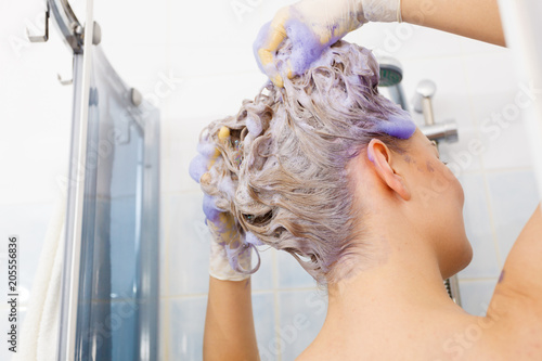 Woman applying toner shampoo on her hair