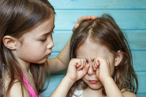 The girl calms her crying friend. Children's friendship, support