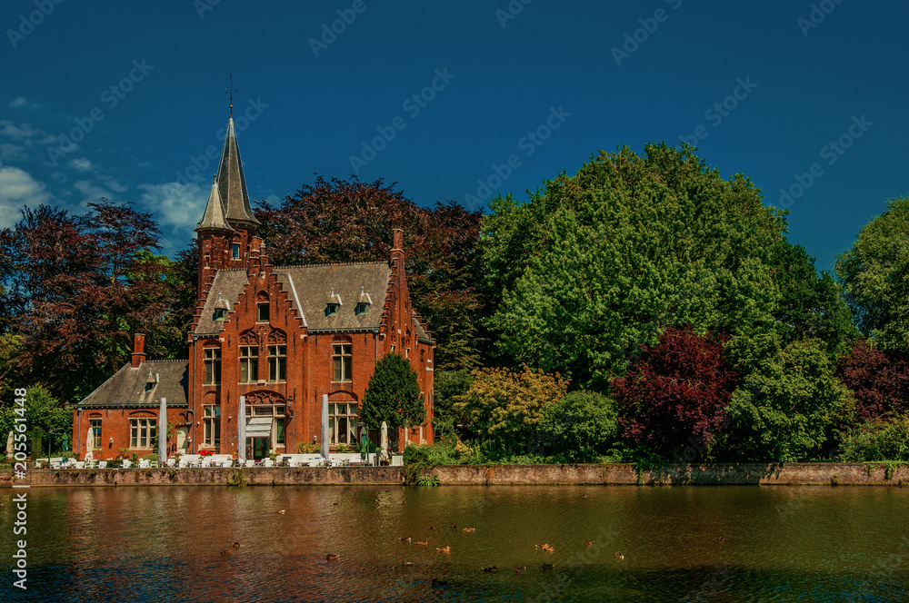 Amazing lake surrounded by greenery and old brick building in Bruges. With many canals and old buildings, this graceful town is a World Heritage Site of Unesco. Northwestern Belgium. Retouched photo Amazing lake surrounded by greenery and old brick building in Bruges. With many canals and old buildings, this graceful town is a World Heritage Site of Unesco. Northwestern Belgium. Retouched photo