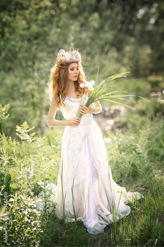 Fairy-tale princess in the crown in a magical forest.