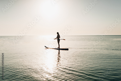 silhouette of a sexy athletic girl who sails on kayaks