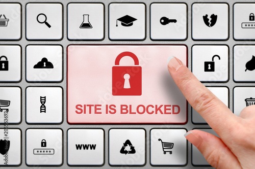 Billede på lærred Site blocked concept, girl's finger above the big button on the keyboard