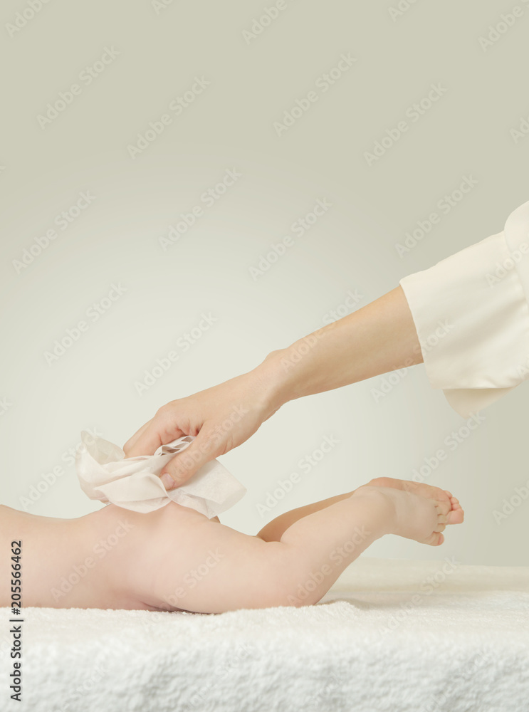 Newborn baby getting a diaper change mom wiping baby's bottom with