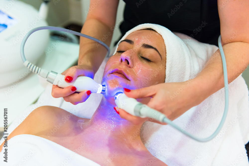 Young pretty woman during a microdermabrasion treatment with professional tool in aesthetic center Young pretty woman during a microdermabrasion treatment with professional tool in aesthetic center