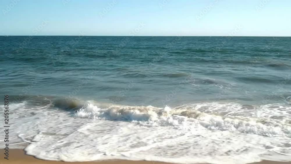 A warm summer day next to the pacific ocean. Waves crashing on the sand next to the local pier A warm summer day next to the pacific ocean. Waves crashing on the sand next to the local pier
