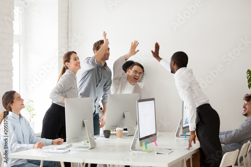 Fotografija Happy multi-ethnic employees sales team giving high five together celebrating co