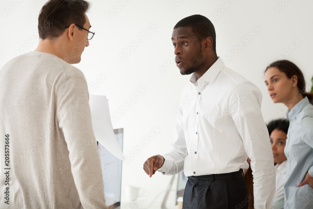 Diverse black employee and white boss arguing in office, african worker disagreeing with dismissal firing protecting rights or behaving rudely, multiracial conflict at work and racial discrimination Diverse black employee and white boss arguing in office, african worker disagreeing with dismissal firing protecting rights or behaving rudely, multiracial conflict at work and racial discrimination