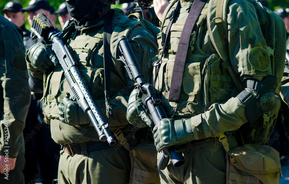 Soldiers in dark green uniform holding weapon. Concept of military conflict  Stock Photo | Adobe Stock