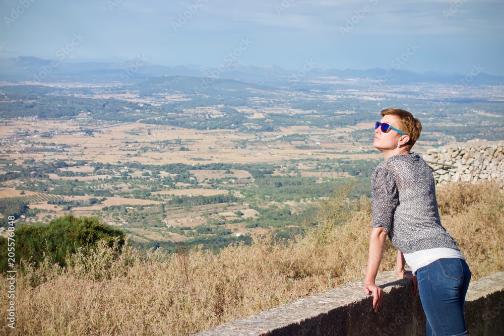 woman with blue sunglasses looking Curious at the sky in Santuari de Cura, Mallorca, Spain woman with blue sunglasses looking Curious at the sky in Santuari de Cura, Mallorca, Spain