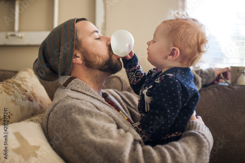 Son playing with bubble gum blew by father at home photo