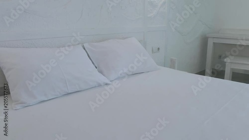 A hotel room with a white double bed, blue sofa and blue curtains photo