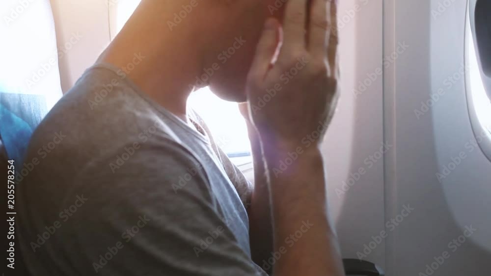headache in the airplane, man passenger afraid and feeling bad and sick during the flight in plane, aerophobia headache in the airplane, man passenger afraid and feeling bad and sick during the flight in plane, aerophobia
