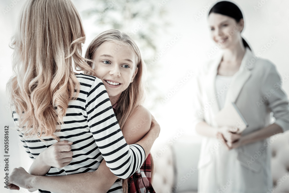 Love you so much Cute satisfied gay girl standing in the bright room and hugging her mother. Love you so much Cute satisfied gay girl standing in the bright room and hugging her mother.