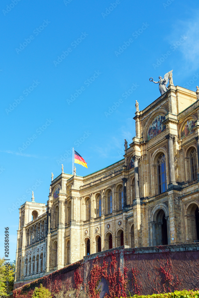 Obraz premium Waving German flag above The Maximilianeum (1874), seat of Bavarian Landtag, Munich, Germany